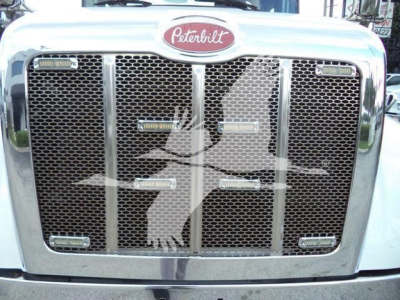 Peterbilt 337 grille with chrome surround and mesh, Peterbilt emblem centered above, truck headlight pods on sides.