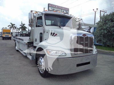 Peterbilt 337 rollback truck in silver exterior, front view with chrome grille and hood, JT61994FM visible, logo on grille.