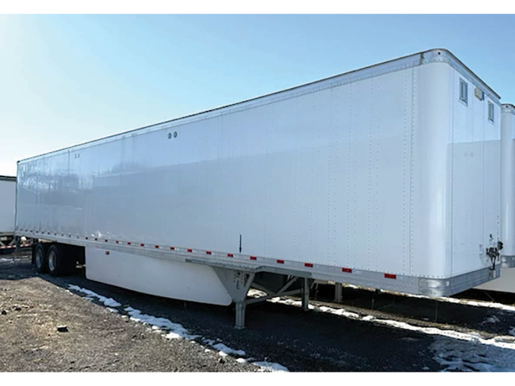Aluminum dry van trailer showing side profile with tandem axles, plain white exterior, and rear doors; no legible text visible on the trailer.