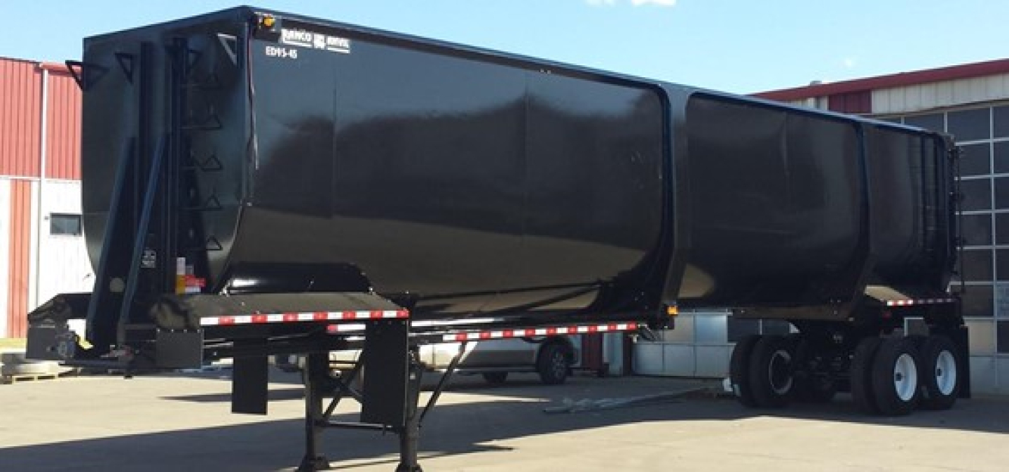 Ranco dump/demolition trailer in a parking lot showing large black dump body and dual rear axles.