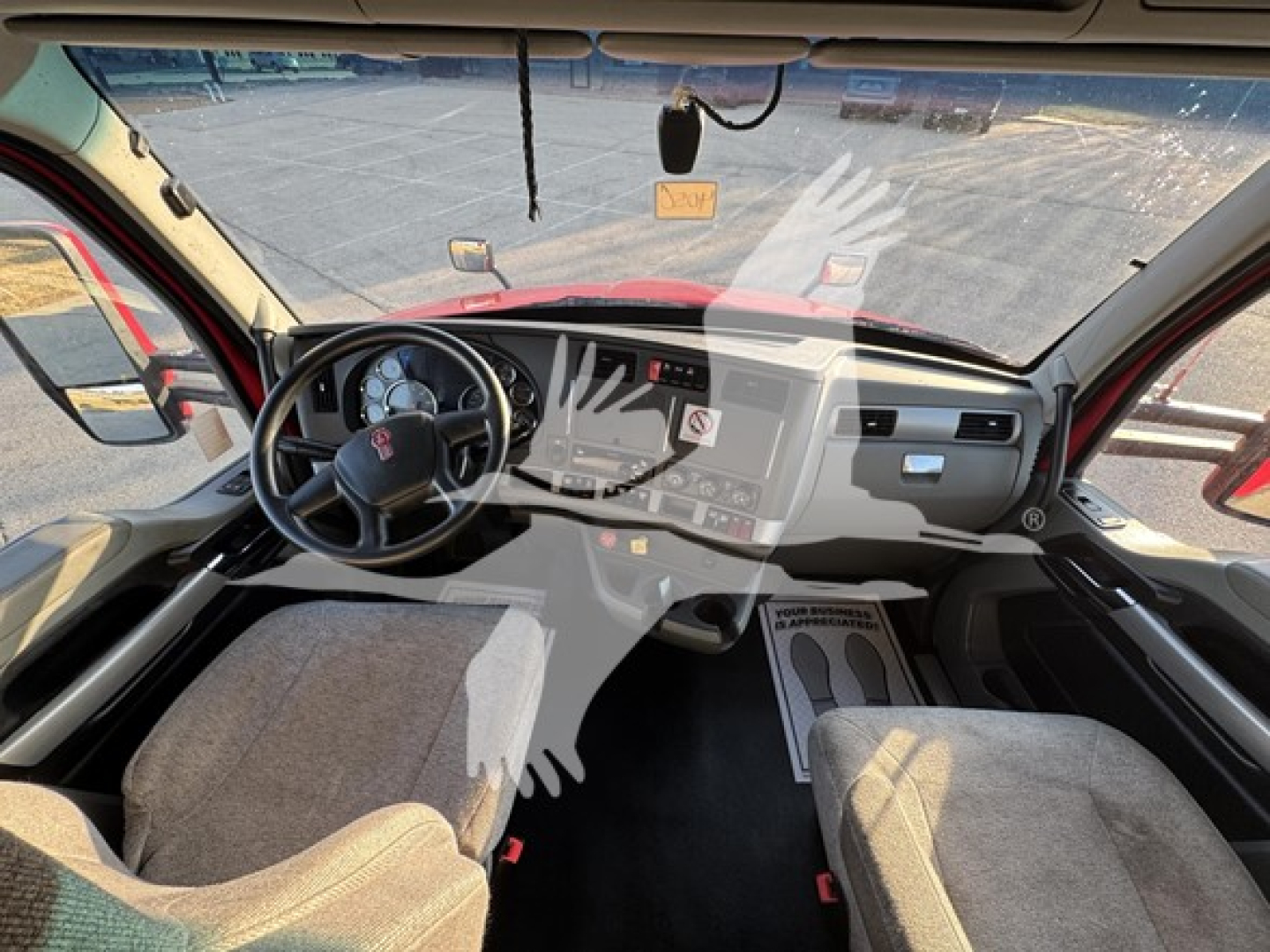 Cab interior of a 2020 Kenworth T680 from the driver's seat perspective showing steering wheel, dashboard, center console, and front seats.