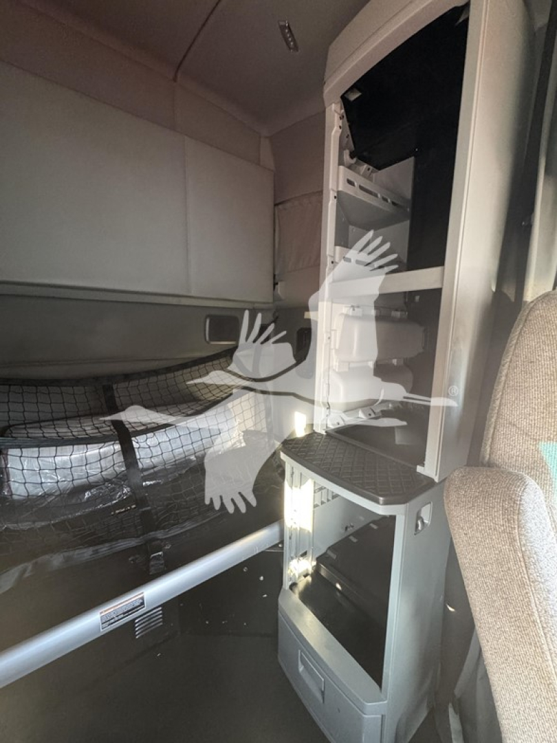 Kenworth T680 cab interior showing vertical storage compartments and open dash area with racks and shelves.