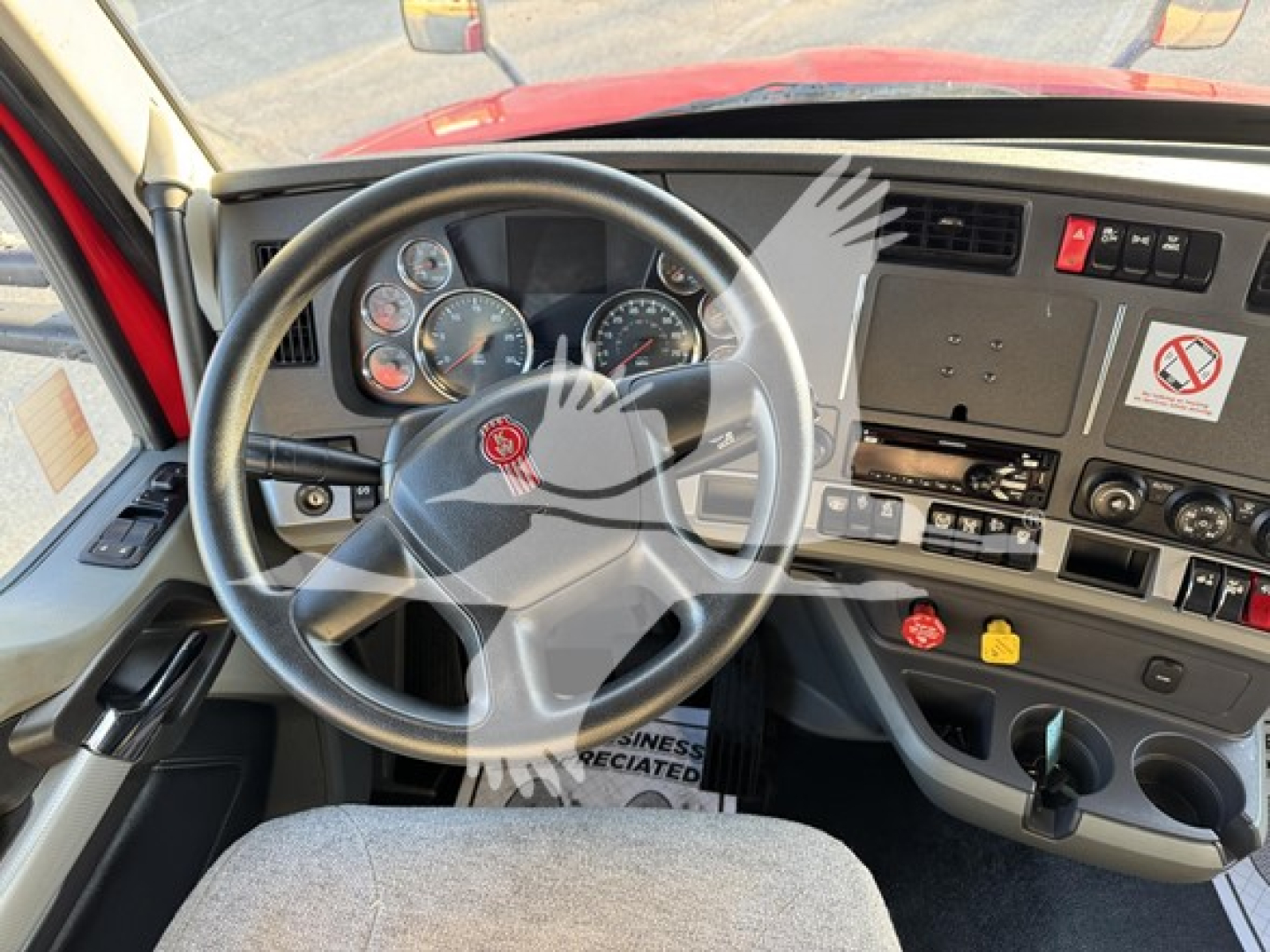 Kenworth T680 steering wheel and dashboard view from driver seat showing instrument cluster, center console, and controls.