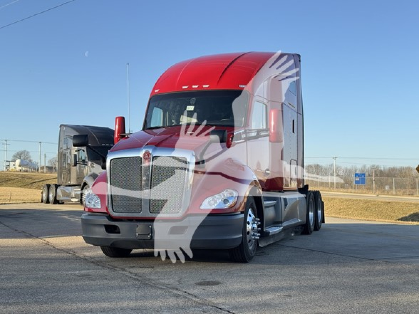 Kenworth T680 conventional sleeper truck in red and gray, front view, parked outdoors.