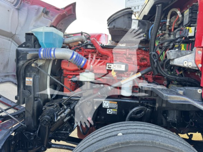 Kenworth T680 engine bay showing coolant reservoir, turbo hoses, air intake, and EMZ/Exis label visible in the engine compartment.