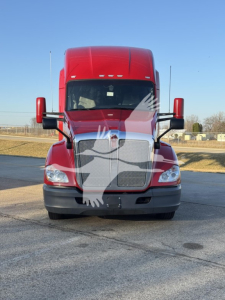 Kenworth T680 front view showing large chrome grille, dealer watermark on windshield, red cab, black bumper, side mirrors