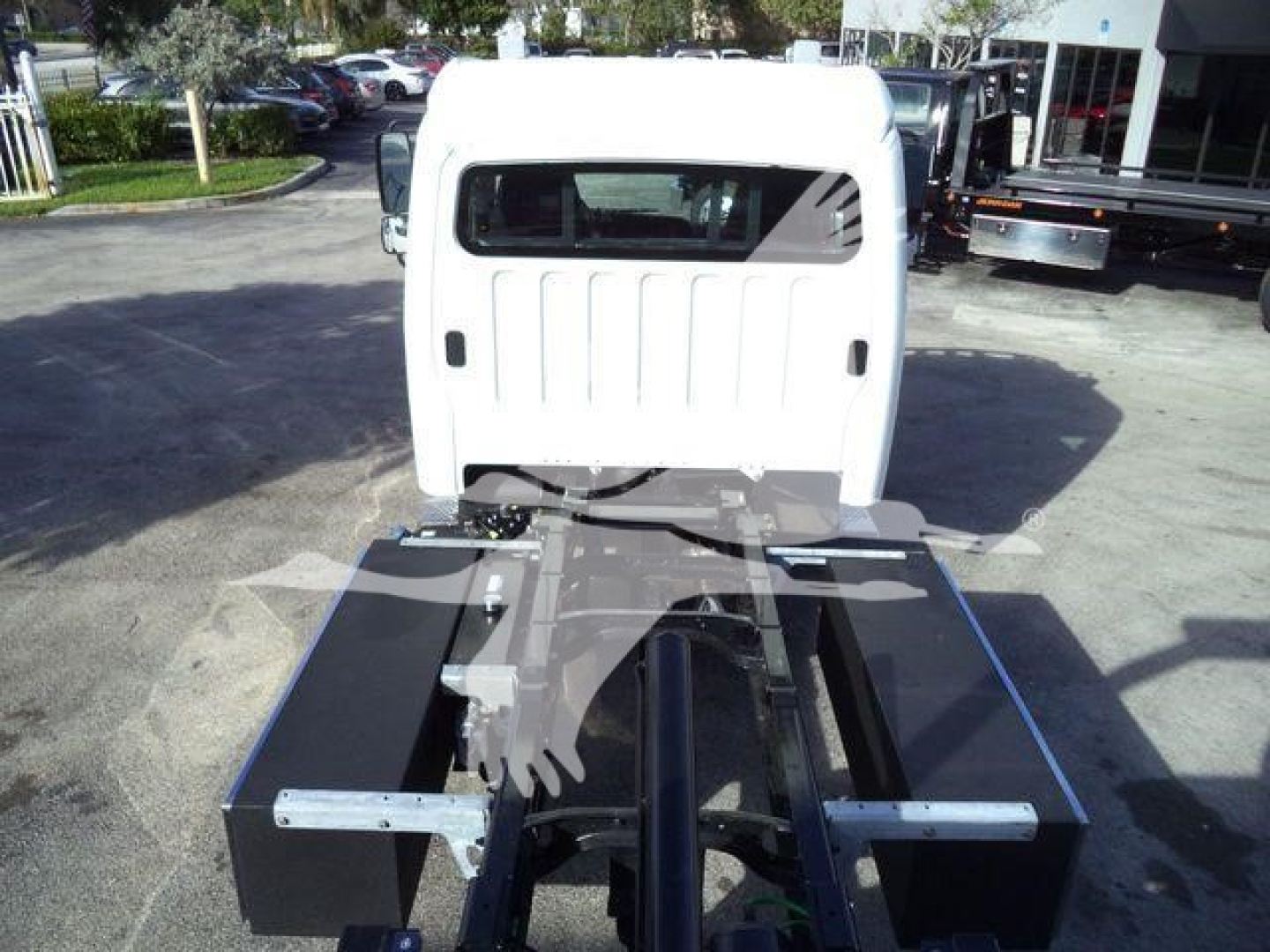 Front cab and chassis of a Freightliner M2 106 Plus rollback truck showing bare chassis, frame rails, and attachment points.