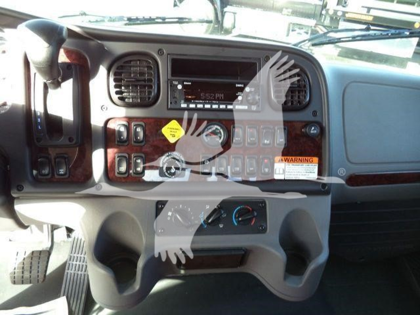 Dashboard view of a Freightliner M2 106 Plus cab showing control panel, gauges, and center console.