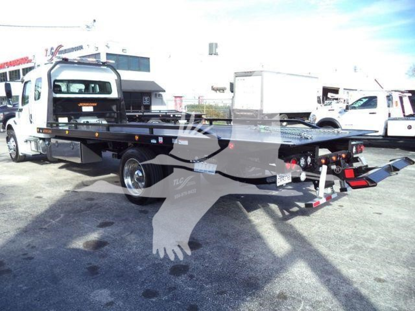Flatbed tow truck chassis on a 2027 Freightliner M2 106 Plus with rollback gear and hydraulic system visible.