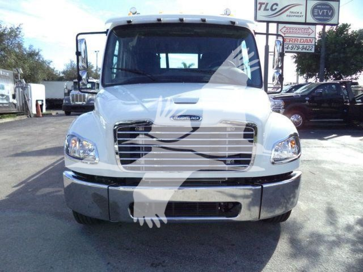 Front view of a white 2027 Freightliner M2 106 Plus truck with chrome grille and bumper, parked in a dealership lot.