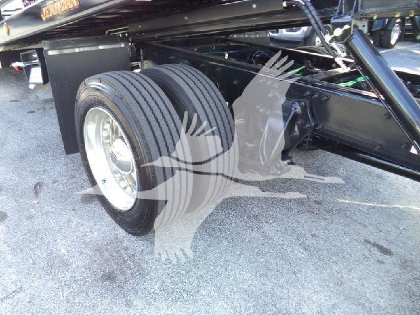 Freightliner M2 106 Plus rollback truck rear wheel and undercarriage showing dual rear tires and frame components.