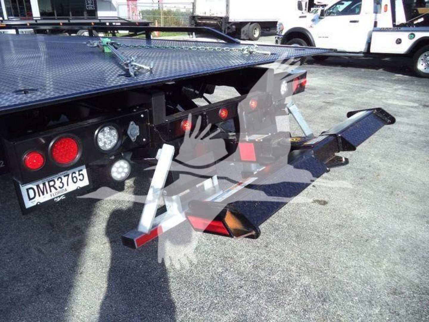 Rear view of a 2027 Freightliner M2 106 Plus rollback truck showing platform and equipment hooks, lights, and license plate area.
