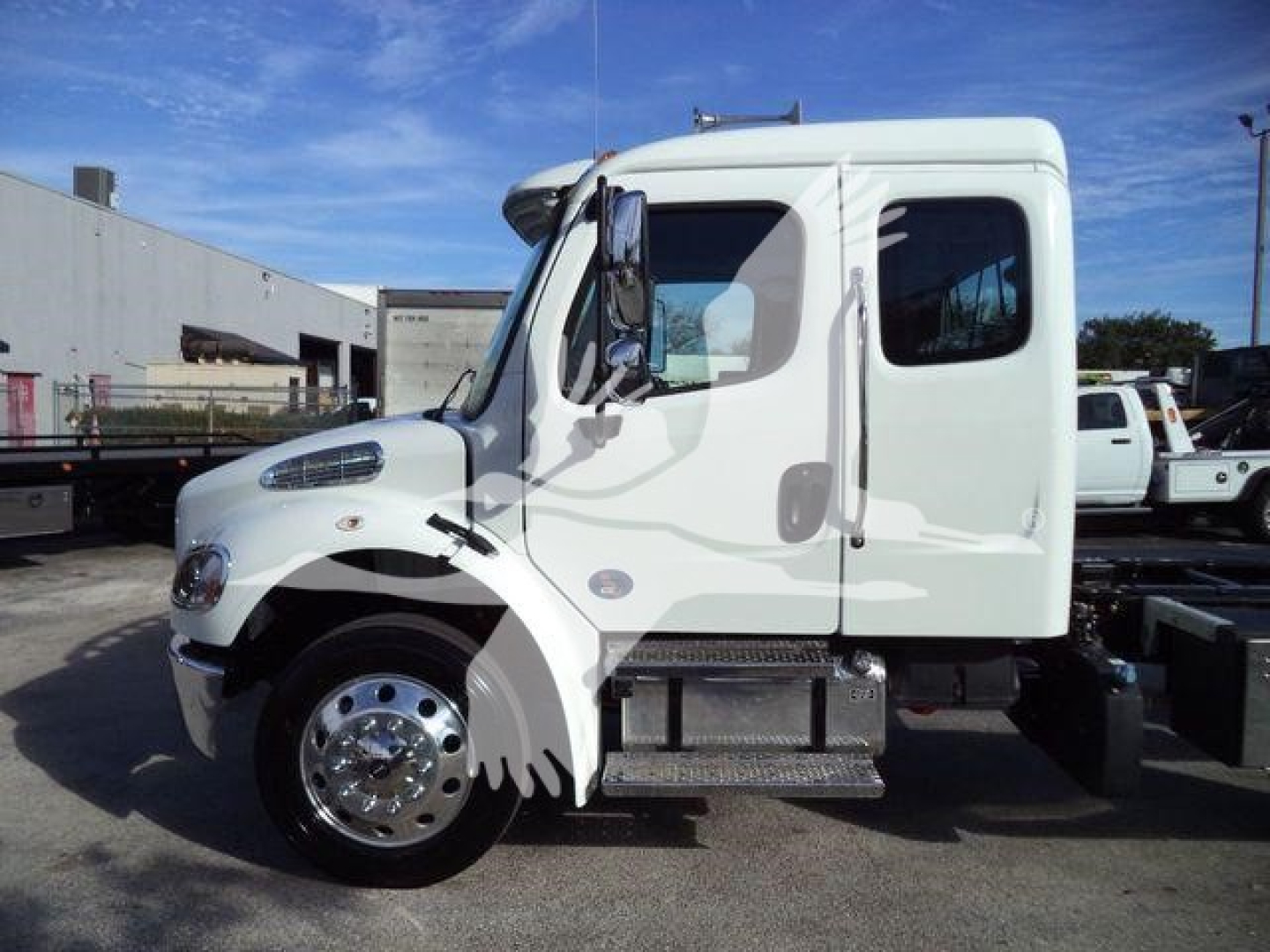 Truck cab side view showing Freightliner M2 106 Plus with white exterior, single rear axle, and steps. Visible text not legible.