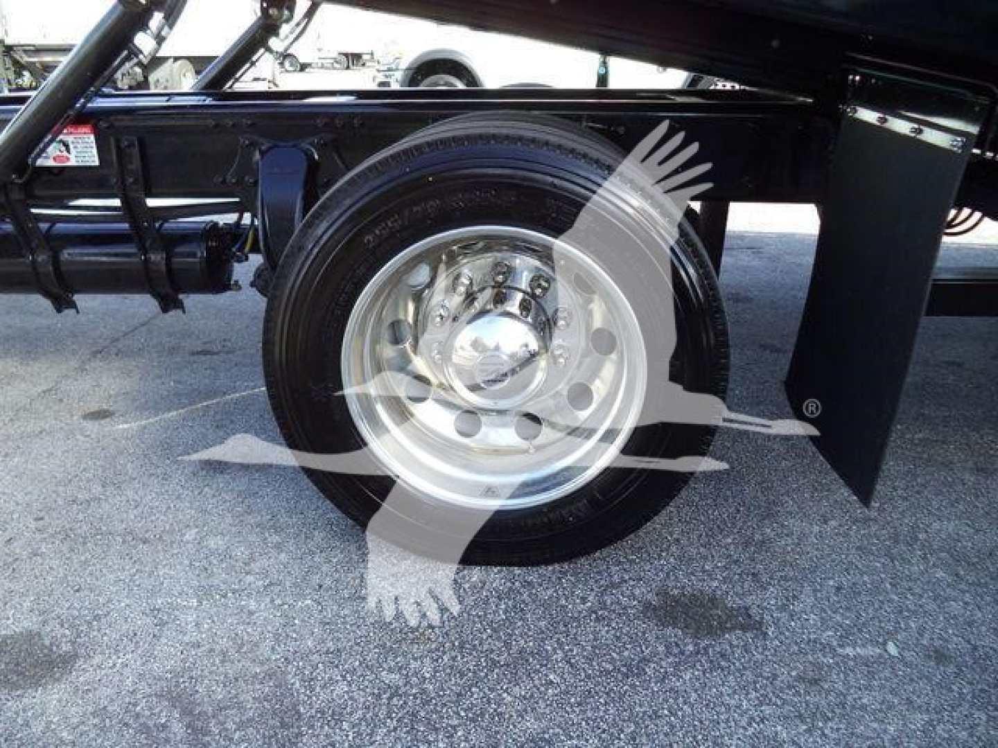 Wheel and undercarriage of Freightliner M2 106 Plus chassis showing a single steel wheel with tire mounted and frame components nearby