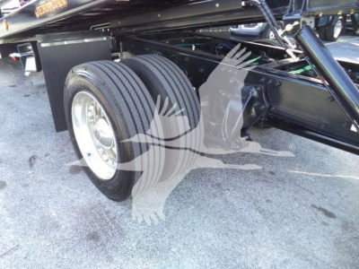 Freightliner M2 106 Plus rollback truck rear wheel and undercarriage showing dual rear tires and frame components.