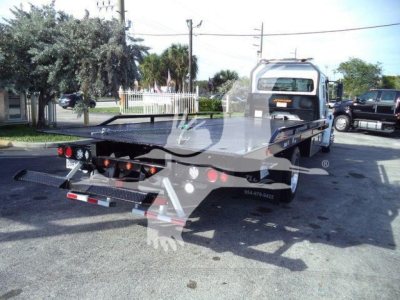 Truck bed of a Freightliner M2 106 Plus rollback showing rear view with ramps and lights.