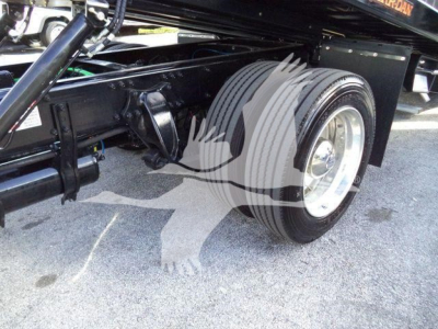 Truck chassis with dual rear wheels and suspension visible under Freightliner M2 106 Plus rollback model.