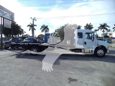 2027 Freightliner M2 106 Plus rollback truck side view showing white cab and rollback bed with palm trees in background.