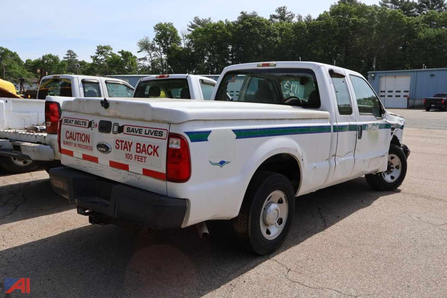 2008 Ford F-250 Super Duty pickup truck with back cargo area showing protective branding and caution decals on tailgate and side panel.