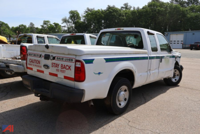 2008 Ford F-250 Super Duty pickup truck with back cargo area showing protective branding and caution decals on tailgate and side panel.
