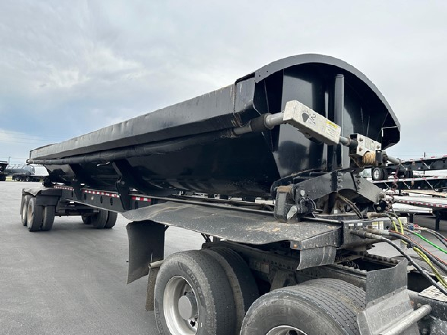 Trailer side dump with Jet Air Ride system showing hydraulic components and elongated dump bed.