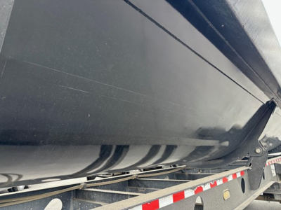 Side view of a Jet Air Ride Jet side-dump trailer showing the hull and hydraulic assembly under the trailer bed.