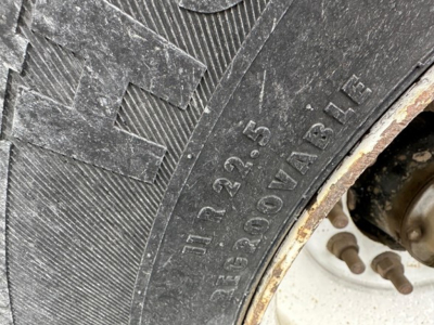 Tire of a Jet Side Dump trailer showing tread and wheel with stamped numbers 11R22.5 13 30/60  IA书? Not needed.