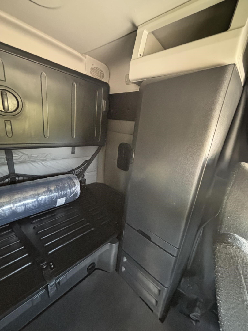 Cab interior showing storage cabinet and sleeper area in a Freightliner Cascadia truck