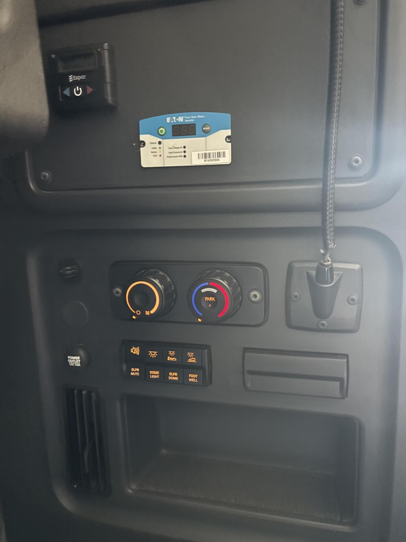 Truck dash area showing climate controls and switches with a blue/white label sticker on the dash. Visible text includes a blue label with barcodes, circular gauges, and a scannable tag.