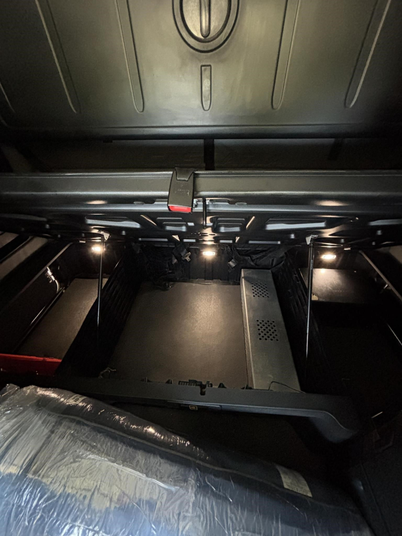 Freightliner Cascadia sleeper cab interior showing under bunk area with storage compartments and metal framework.