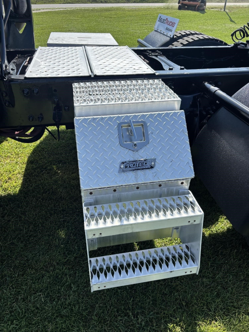Step box and diamond-plate toolbox mounted on Freightliner Cascadia truck chassis showing aluminum diamond-plate steps and toolbox with Freightliner badge.