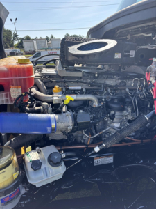Freightliner Cascadia 126 engine bay showing radiator reservoir, hoses, and exposed engine components.