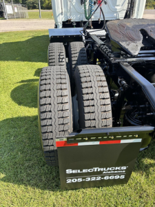 Truck chassis rear view with dual rear axles and tires visible; mudflap shows ‘SELECT TRUCKS Alabama 205-322-6695’
