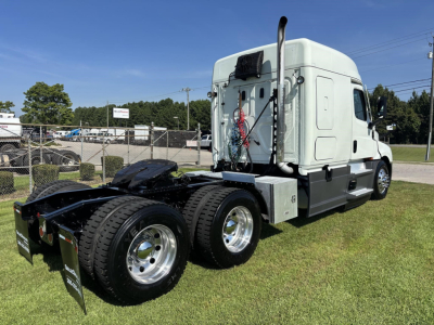Freightliner Cascadia 126 sleeper cab tractor truck at a lot, rear and side view showing dual rear axles and chrome wheels.