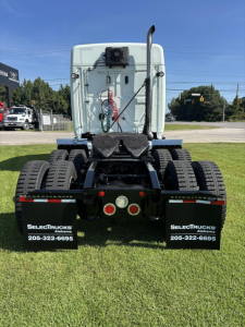 Rear view of a Freightliner Cascadia sleeper tractor showing fifth wheel, twin rear axles, and dual mud flaps with SelectTrucks Alabama contact numbers.