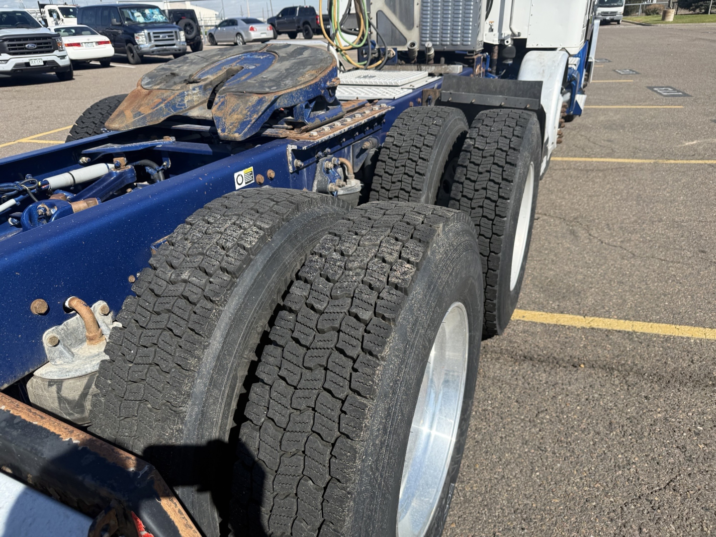 Kenworth T880 chassis showing dual rear axles and tires, blue frame, fuel/air lines and fifth wheel assembly visible.