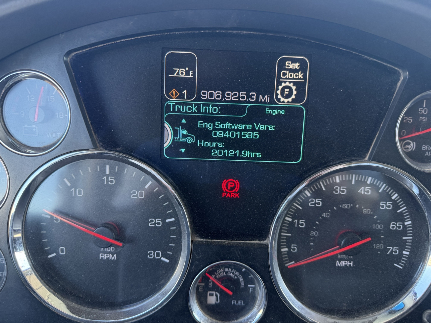 Truck instrument cluster with digital display showing 906,925.3 miles, engine software version 080401685, hours 20121.9hrs, and gear indicators.
