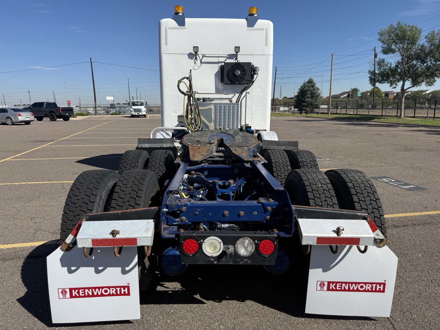 Kenworth T880 rear view showing dual rear axles and bumper-mounted lights with Kenworth mud flaps.