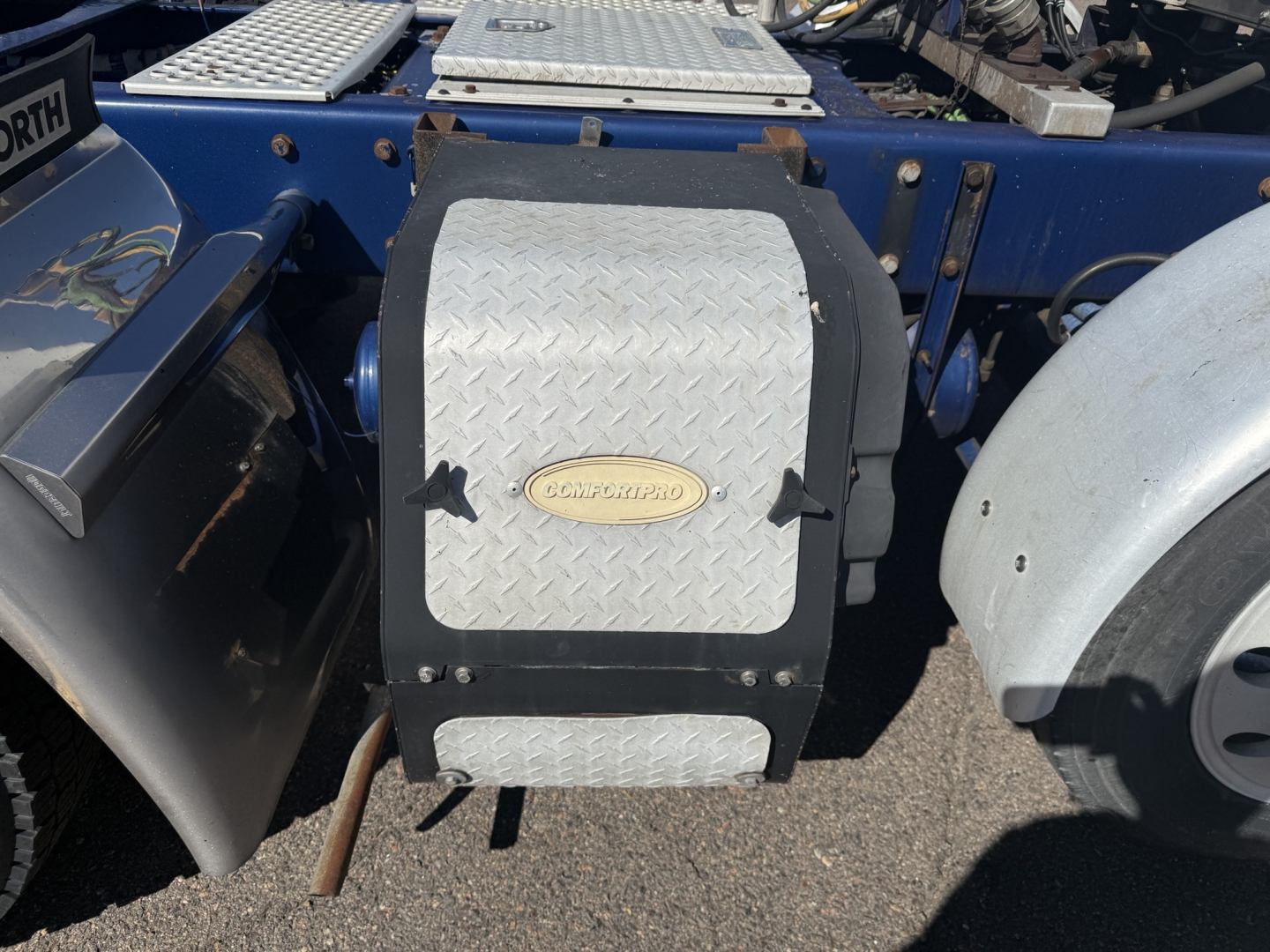 Kenworth T880 side toolbox with diamond plate cover and fuel line access, cab behind, blue chassis.
