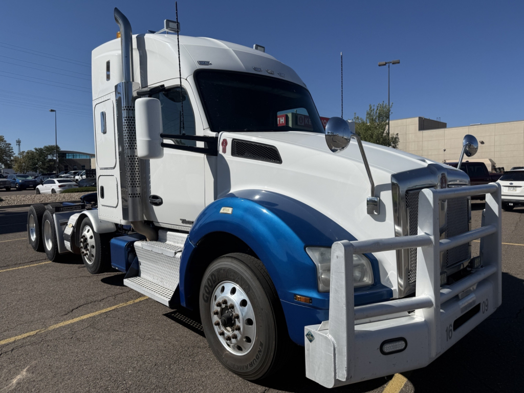 Kenworth T880 conventional sleeper truck side view showing front bumper guard and white and blue color scheme.