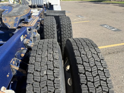 Conventional sleeper truck chassis showing dual rear wheels and heavy tread tires of a 2016 Kenworth T880