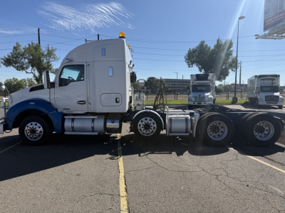 Kenworth T880 truck cab and chassis side view showing sleeper cab and dual rear axles.