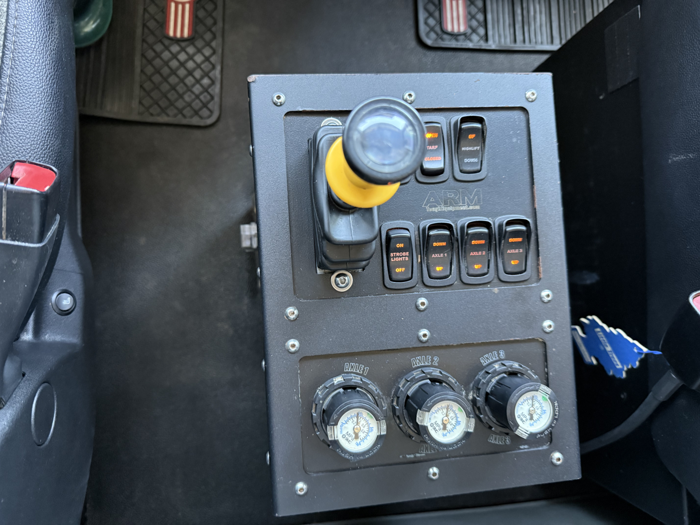 Kenworth T880 dash panel with yellow-guarded joystick and multiple switches and three circular gauges