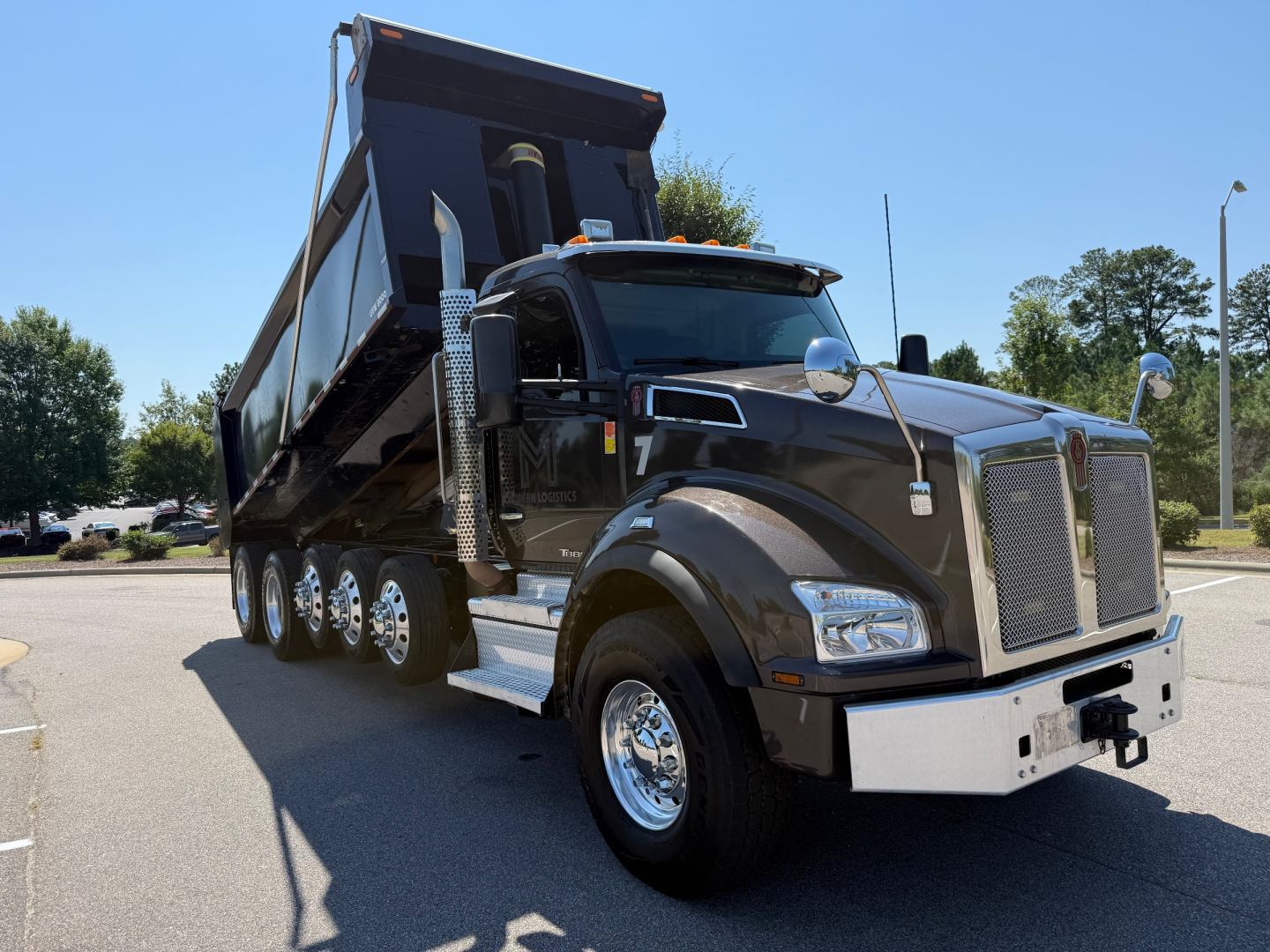 Kenworth T880 dump truck in-service showing large grille, chrome bumper, dual exhaust stacks, and raised dump bed.