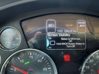 Dashboard of a 2022 Kenworth T880 showing speedometer, tachometer, digital display with mileage 166,168.1 miles, and a red PARK brake indicator.