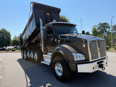 Kenworth T880 dump truck in-service showing large grille, chrome bumper, dual exhaust stacks, and raised dump bed.