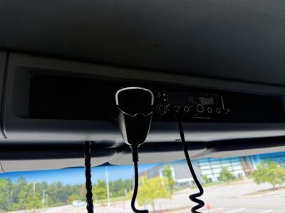 Dashboard area of a 2022 Kenworth T880 truck showing a hanging mic or headset and radio controls under the windshield.
