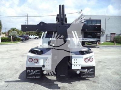 Truck rear view with heavy-duty winch and hitch equipment mounted on flatbed, Ram 2024 branding not visible in text; winch apparatus and mounting arms centered.