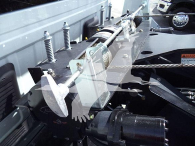 Winch-equipped Ram truck engine bay showing winch drum and cable assembly with mounting hardware and hydraulic lines.