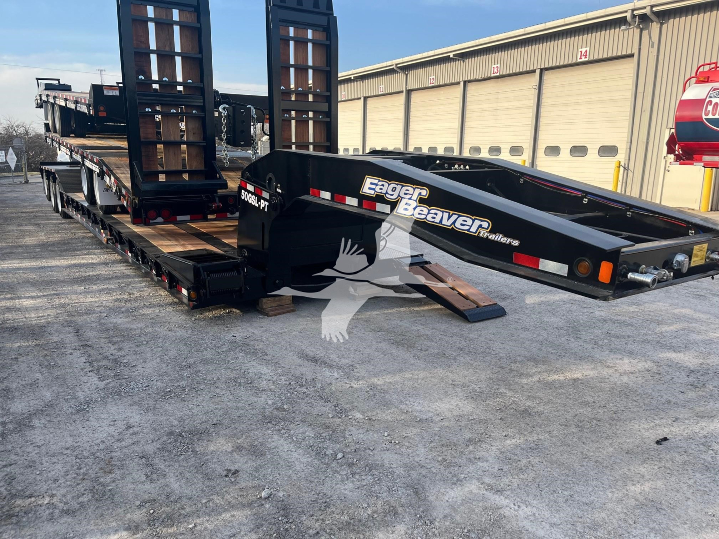 Eager Beaver 50Gsl-Pt lowboy trailer in a yard showing its flatbed deck and hydraulic ramps with branding